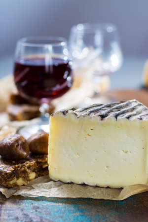 Sweet dessert liqueur wine in glass, hard french cheese Tomme de Montagne and dried figs with figs bread, still lifeの写真素材