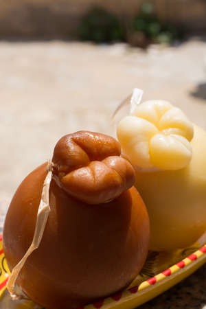 Traditional Italian hard cheese Provolone of Caciocavallo, white and smoked, ready to eatの写真素材