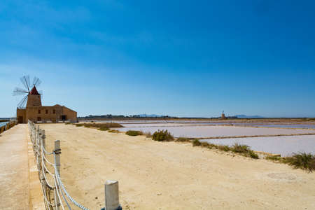 Sea saltworks, salt wind mills are seen in suburbs of Marsala, Sicily, Italy.の写真素材