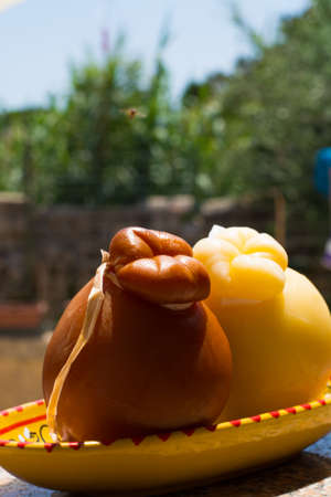 Traditional Italian hard cheese Provolone of Caciocavallo, white and smoked, ready to eatの写真素材