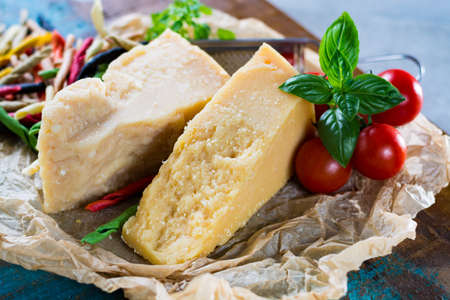 Traditional Italian hard cheese Parmesan and Grana Padano with pasta, tomatoes, basil on wrapperの写真素材