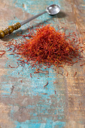 Dried organic red saffron Spice on wooden background with spoonの写真素材