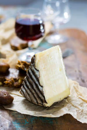 Sweet dessert liqueur wine in glass, hard french cheese Tomme de Montagne and dried figs with figs bread, still lifeの写真素材