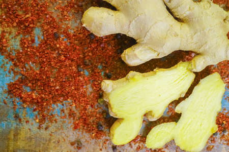 Fresh organic ginger root with powdered Cayenne pepper on the wooden table, used als food ingredient and for medicine.の写真素材
