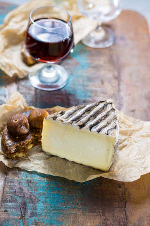 Sweet dessert liqueur wine in glass, hard french cheese Tomme de Montagne and dried figs with figs bread, still lifeの写真素材