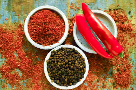 Red hot chili Cayenne and black pepper fresh and dried powdered spice, ready to use on wooden backgroundの写真素材