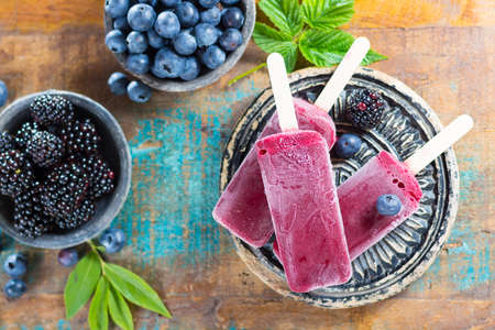 Fresh summer wild blueberries and  brambleberry, home made sorbet ice cream popsicles.の写真素材
