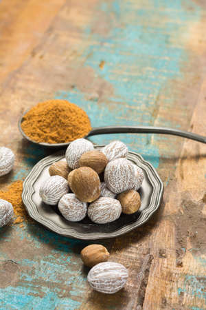 Nutmeg powder. Macro view whole nuts and grated muscat nuts on vintage background.の写真素材