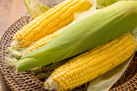 Fresh yellow ripe sweet raw corn on rustic wooden table, closeupの写真素材
