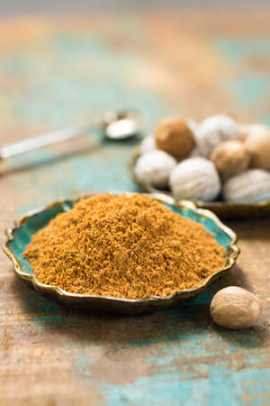 Nutmeg powder. Macro view whole nuts and grated muscat nuts on vintage background.の写真素材