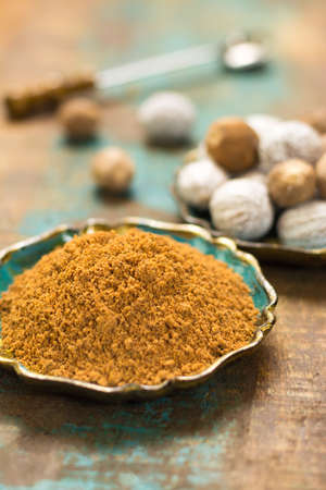 Nutmeg powder. Macro view whole nuts and grated muscat nuts on vintage background.の写真素材