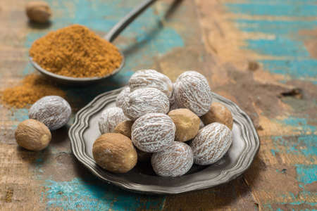 Nutmeg powder. Macro view whole nuts and grated muscat nuts on vintage background.の写真素材