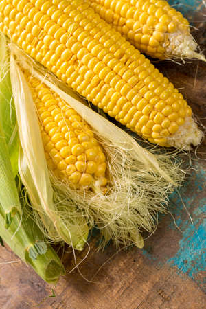 Fresh yellow ripe sweet raw corn on rustic wooden table, closeupの写真素材