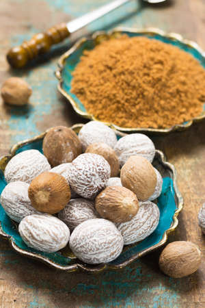 Nutmeg powder. Macro view whole nuts and grated muscat nuts on vintage background.の写真素材