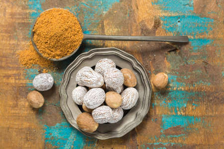 Nutmeg powder. Macro view whole nuts and grated muscat nuts on vintage background.の写真素材