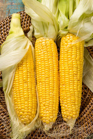 Fresh yellow ripe sweet raw corn on rustic wooden table, closeupの写真素材