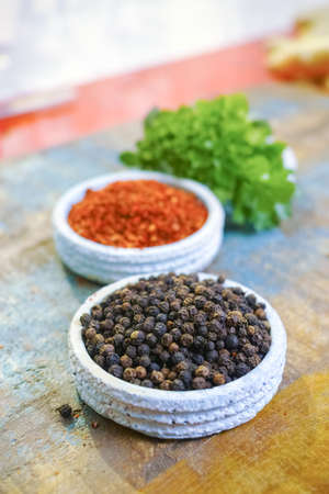 Red hot chili Cayenne and black pepper fresh and dried powdered spice, ready to use on wooden backgroundの写真素材