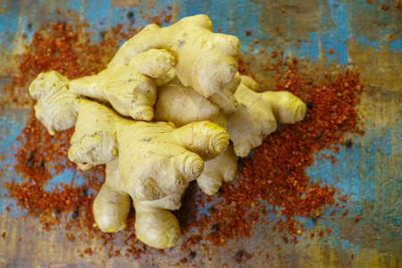 Fresh organic ginger root with powdered Cayenne pepper on the wooden table, used food ingredient and for medicine.の写真素材