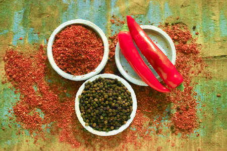 Red hot chili Cayenne and black pepper fresh and dried powdered spice, ready to use on wooden backgroundの写真素材