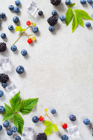 Fresh summer wild blueberries and  brambleberry, strawberry and ice cubesの写真素材