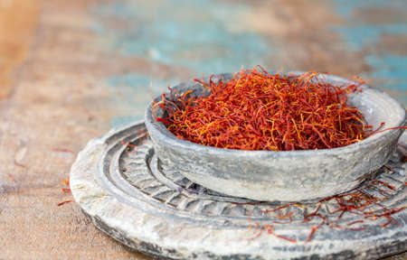 Dried organic red saffron Spice on wooden background with spoonの写真素材