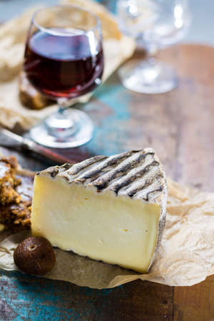 Sweet dessert liqueur wine in glass, hard French cheese Tomme de Montagne and dried figs with figs bread, still lifeの写真素材