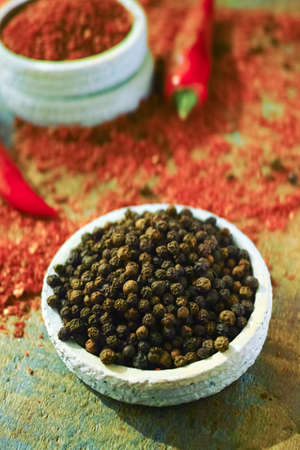 Black pepper and Red hot chili Cayenne  fresh and dried powdered spice, ready to use on wooden backgroundの写真素材