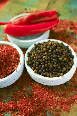 Red hot chili Cayenne and black pepper fresh and dried powdered spice, ready to use on wooden backgroundの写真素材