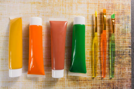 Colours of the nature - mix of green, yellow and brown - home or office interieur design concept, tubes with acrylic paint and  brushes, close upの写真素材