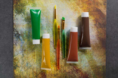 Colours of the nature - mix of green, yellow and brown - home or office interieur design concept, tubes with acrylic paint and  brushes, close upの写真素材