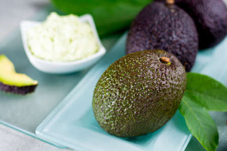 Avocado skin & hair care home spa, ripe avocados and bowl with homemade fresh avocado mask, nature laboratoryの写真素材