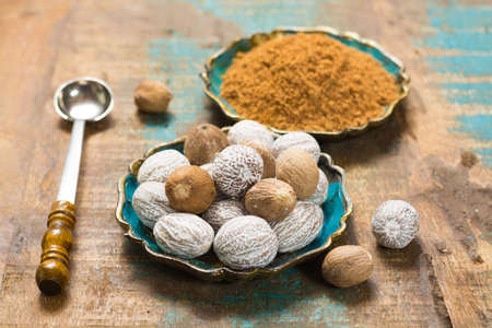 Nutmeg powder. Macro view whole nuts and grated muscat nuts on vintage background.の写真素材
