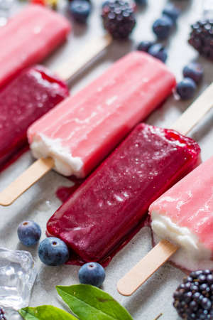 Fresh summer wild blueberries and  brambleberry, strawberry and home made ice cream popsicles.の写真素材