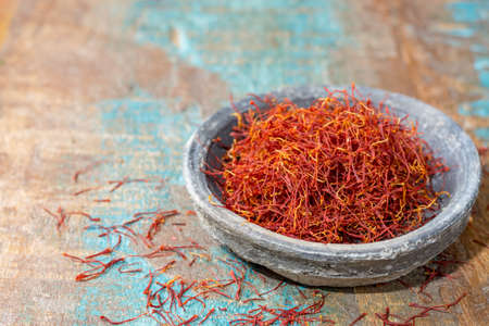 Dried organic red saffron Spice on wooden background with spoonの写真素材