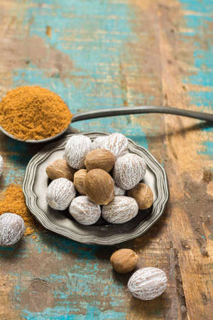 Nutmeg powder. Macro view whole nuts and grated muscat nuts on vintage background.の写真素材