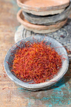 Dried organic red saffron Spice on wooden background with spoonの写真素材