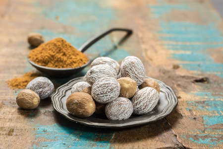 Nutmeg powder. Macro view whole nuts and grated muscat nuts on vintage background.の写真素材