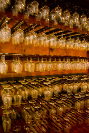 Motion blur concept. Rows of many empty wine glasses on the showcaseの写真素材