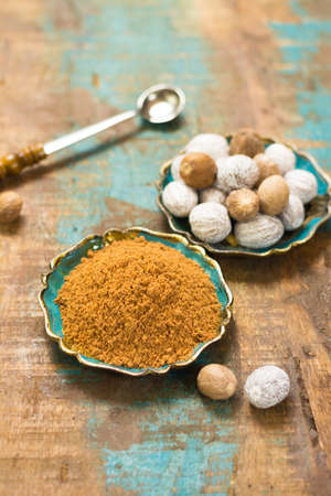 Nutmeg powder. Macro view whole nuts and grated muscat nuts on vintage background.の写真素材
