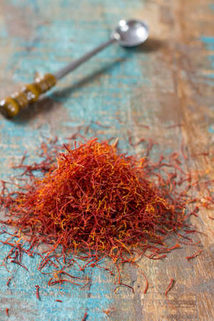Dried organic red saffron Spice on wooden background with spoonの写真素材