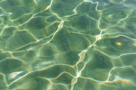 Abstract texture. Water ocean or sea background. Clear blue ripple aqua texture and sun glaresの写真素材