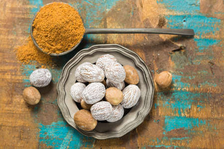 Nutmeg powder. Macro view whole nuts and grated muscat nuts on vintage background.の写真素材