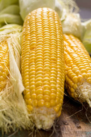 Fresh yellow ripe sweet raw corn on rustic wooden table, closeupの写真素材
