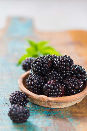 Fresh summer wild blackberries with leaves on wooden backgroundの写真素材