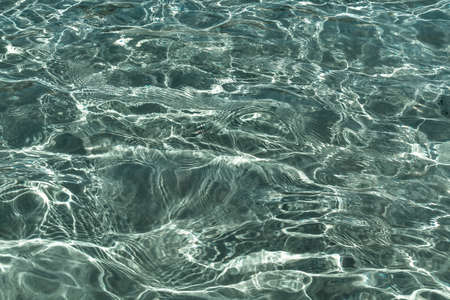Abstract texture. Water ocean or sea background. Clear blue ripple aqua texture and sun glaresの写真素材