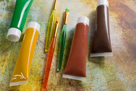 Colours of the nature - mix of green, yellow and brown - home or office interieur design concept, tubes with acrylic paint and  brushes, close upの写真素材