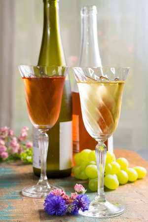 Cold summer wines, white and rose, served in beautiful glasses on terrace in cafe with romantic flowers, close upの写真素材
