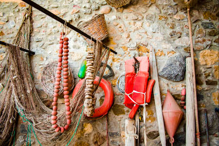 Old ancient fishing nets and tackes on the brick wall, small fisherman village Avola, Sicily, Italyの写真素材