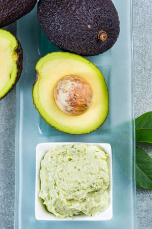 Avocado skin & hair care home spa, ripe avocados and bowl with homemade fresh avocado mask, nature laboratoryの写真素材