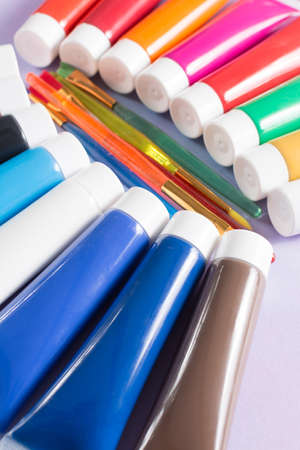 Multicolored rainbow acrylic paints tubes set with five colorful brushes - creative painters conceptの写真素材